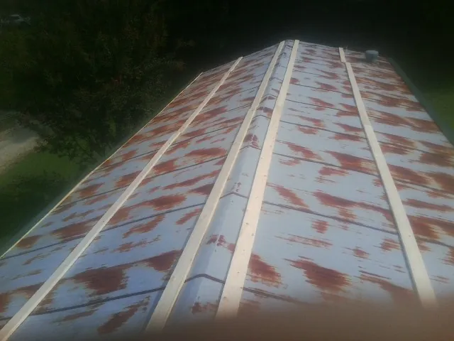 Rusted metal roof panels with new wood purlins before replacement — Storm Damage Roof Repair in Lacombe by Roofing Brothers