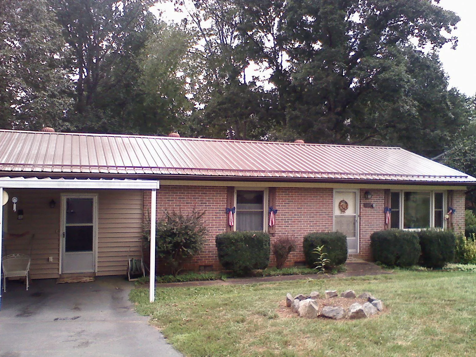 Bronze metal roof and carport on a brick ranch home — Roof Repair work by our crew in Lacombe