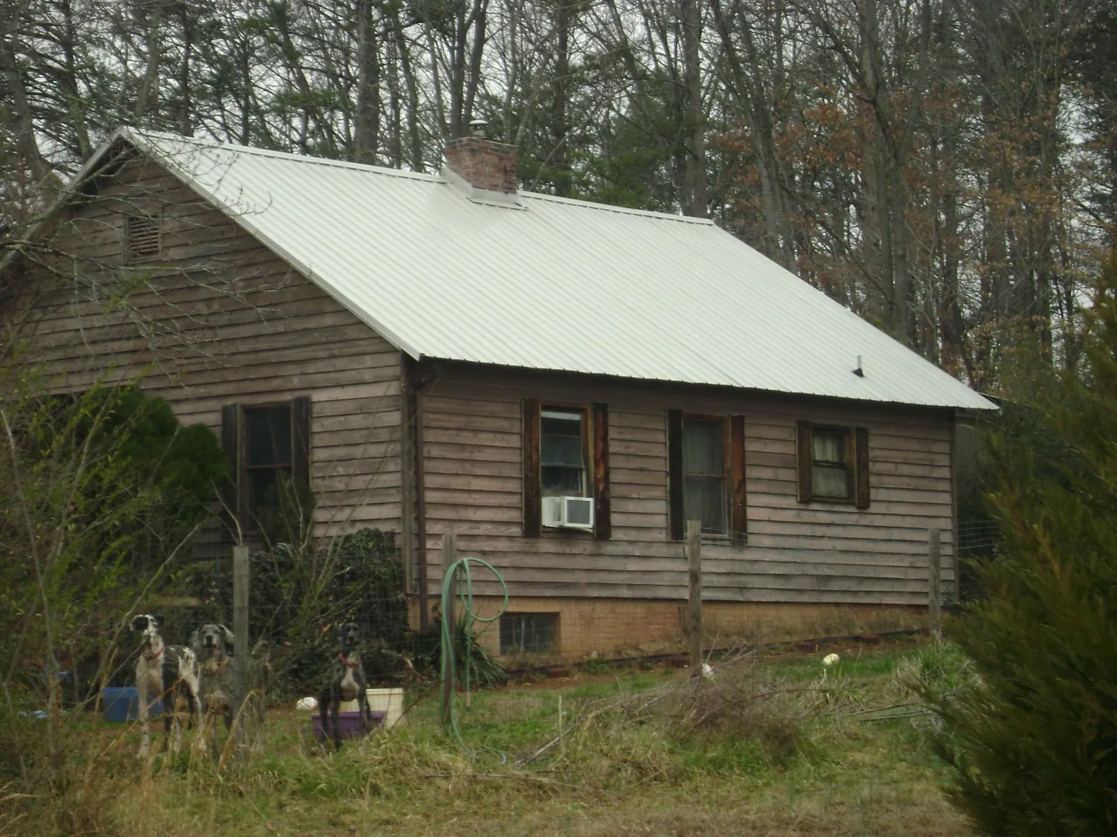 White metal roof on an old wood sided farmhouse, from a Metal Roof Installation job in Lacombe